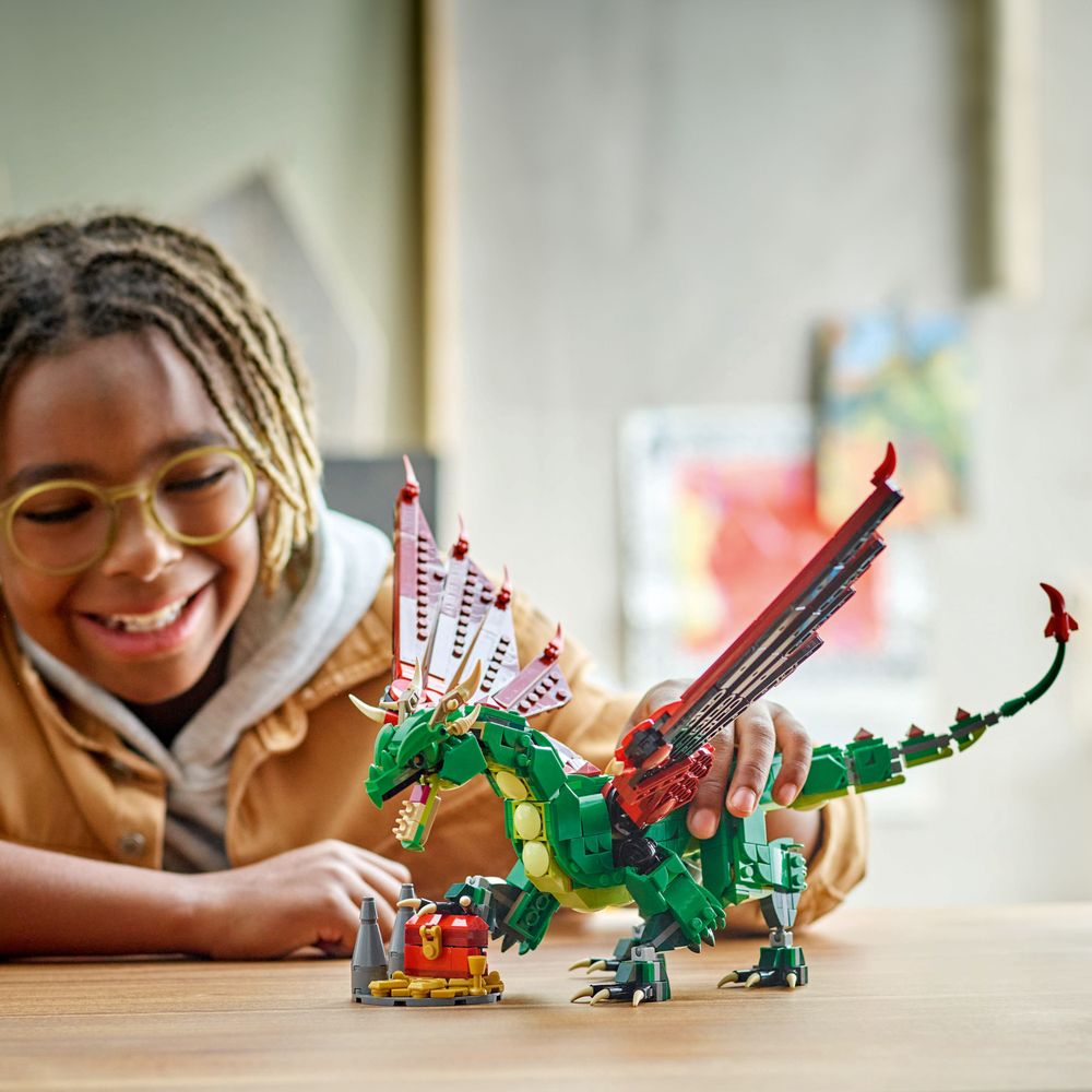 LEGO 31161 Ein Kind spielt mit einem detaillierten grünen Drachen aus LEGO-Steinen.