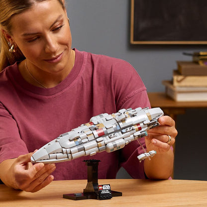 LEGO 75405 Eine Person hält ein detailliertes LEGO-Modell eines Raumschiffes auf einem stabilen Ständer.