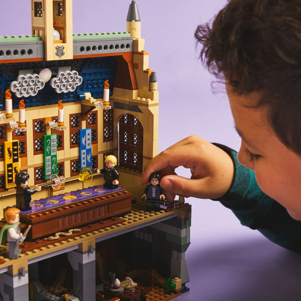 LEGO 76441 Ein Junge spielt mit LEGO Hogwarts Figuren und detailreichem Schloss-Design.