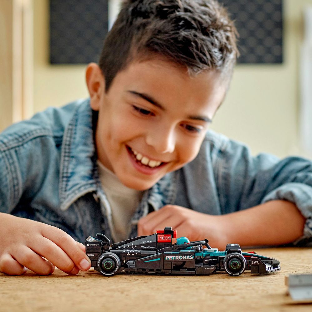 LEGO 77244 Ein Junge erfreut sich am Spielen mit einem LEGO Formel-1-Auto im Ambiente eines Zimmers.